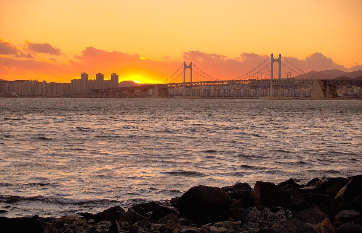 Sunset over the sea at Busan, the Gwangan Bridge silhouetted on the horizon